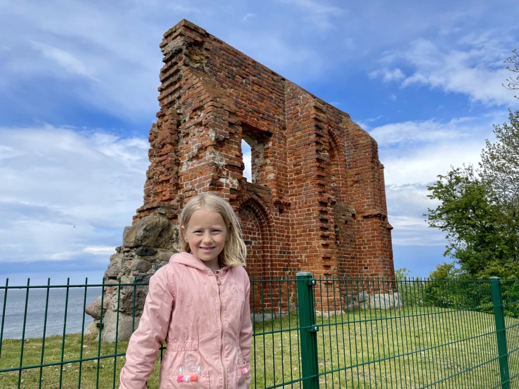 dziecko ogląda ruiny kościoła