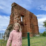 dziecko ogląda ruiny kościoła